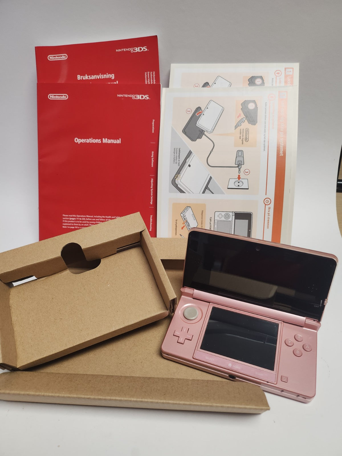 Rosa Nintendo 3DS im Karton mit sämtlichem Zubehör und Broschüren